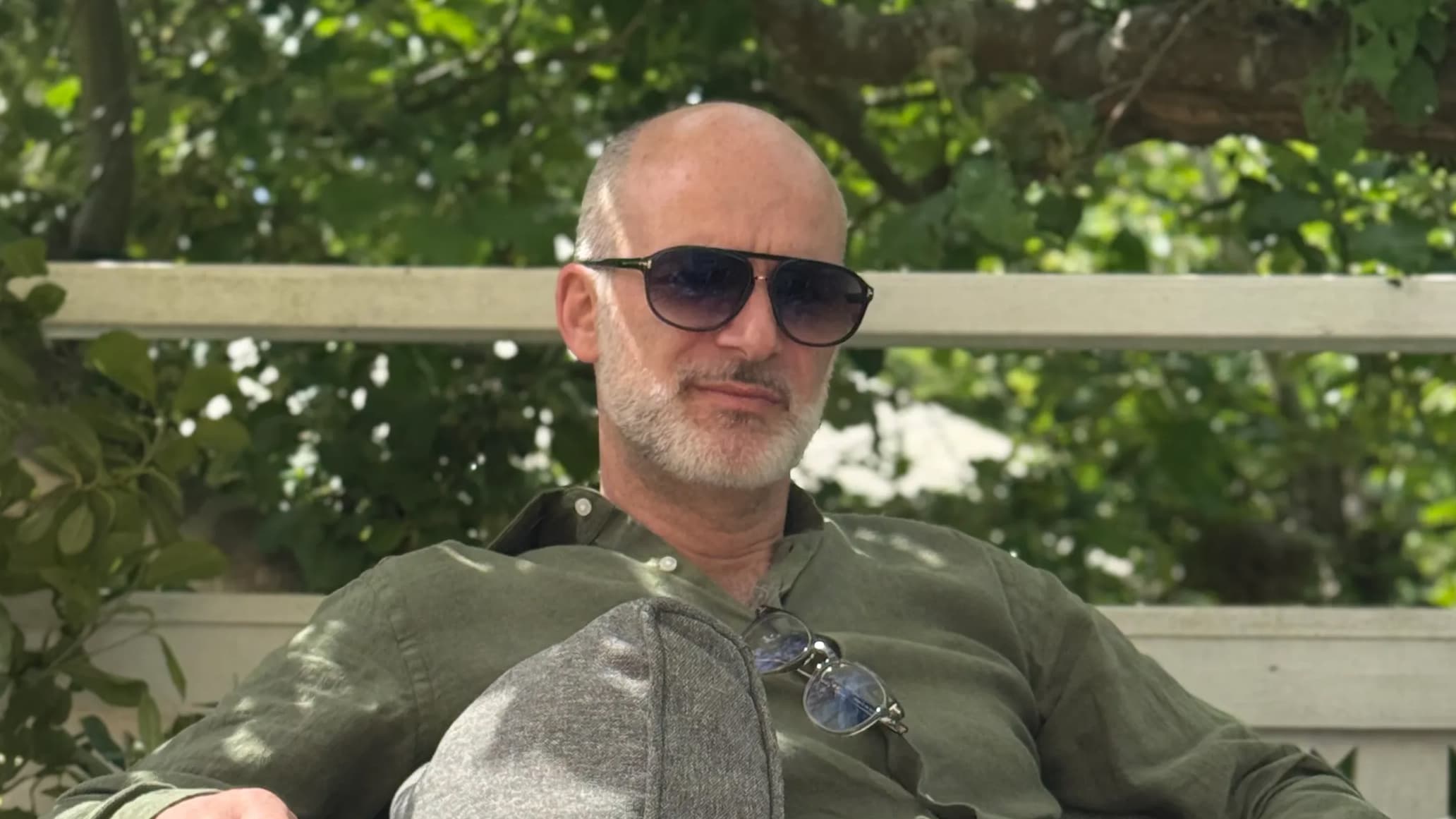 portrait of Dennis Jacobsson sitting outside wearing sunglasses