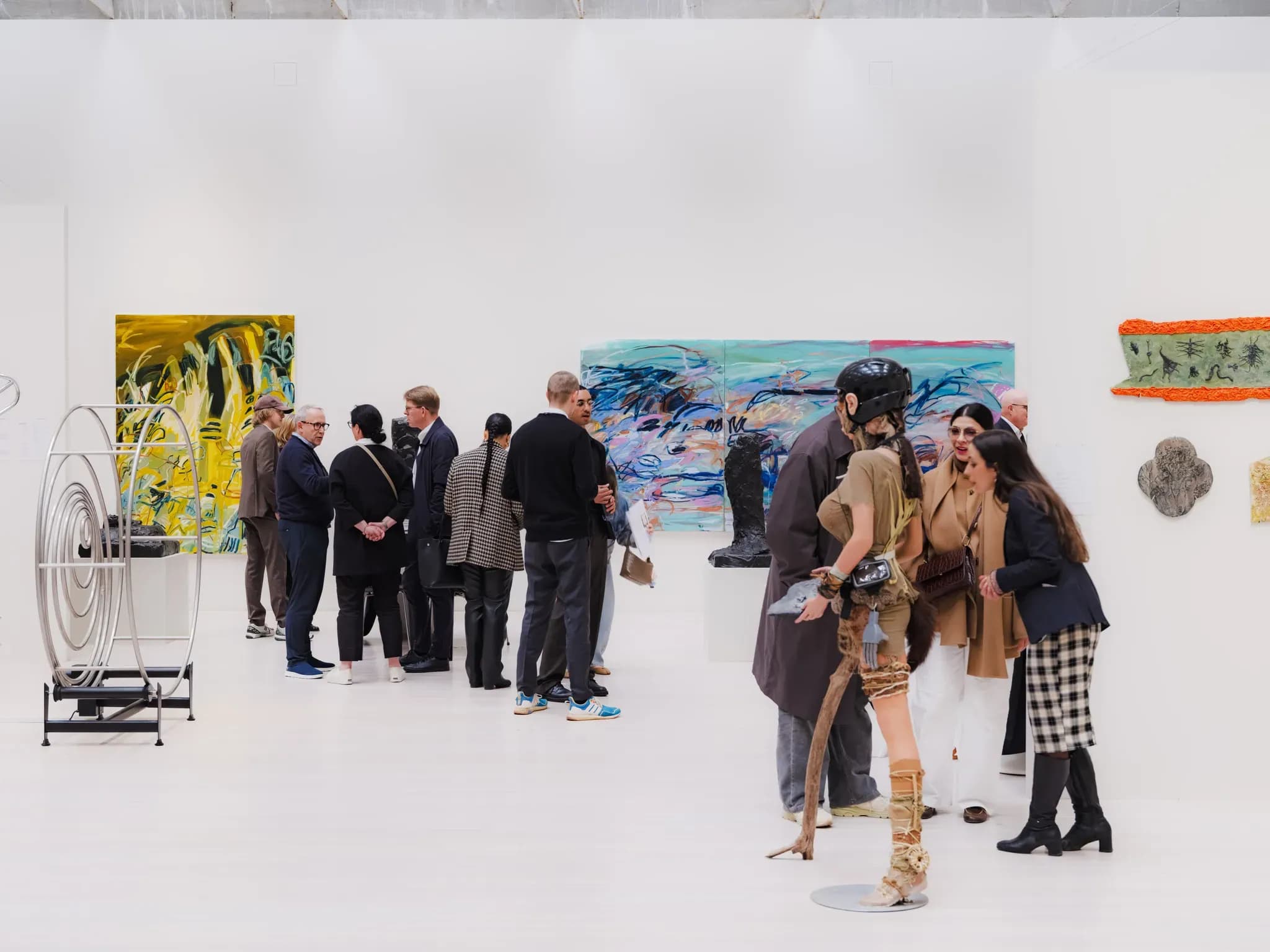 people at art fair looking at paintings and sculptures